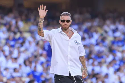 HD PC desktop wallpaper of a bearded, tattooed footballer in sunglasses waving to a cheering crowd in a packed stadium.