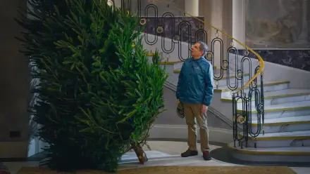 4K Ultra HD PC wallpaper from TV show Man vs Baby: a man in a blue jacket stares at an enormous Christmas tree beside an ornate curved staircase.