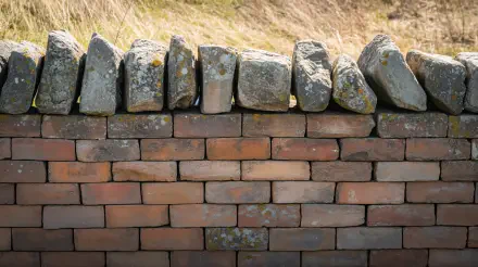 Brick wall topped with weathered stones and a grassy bank, 4K Ultra HD PC desktop wallpaper and background.