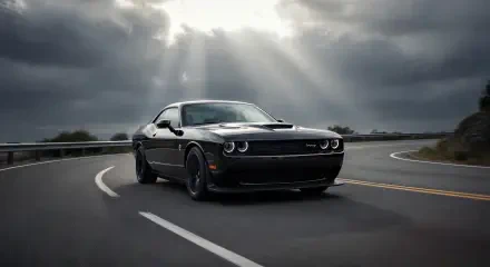 Black Dodge Challenger hugging a curved road beneath dramatic sunlight rays — 2K Quad HD PC desktop wallpaper and background.