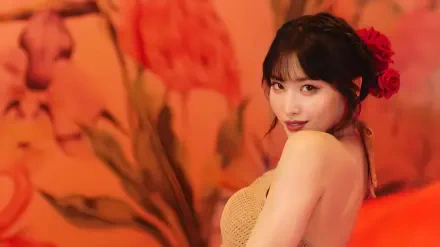 4K Ultra HD PC desktop wallpaper and background: portrait of a smiling woman in a beige dress with red roses in her hair, posed against a warm, blurred orange floral backdrop.