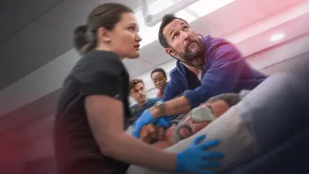 The Pitt — 4K Ultra HD PC desktop wallpaper: tense field-rescue scene with emergency responders in gloves attending an injured person on a gurney under dramatic red-tinted lighting.