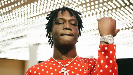 HD PC desktop wallpaper: rapper in a red polka-dot shirt, chain and watch, fist raised beneath bright studio lights.