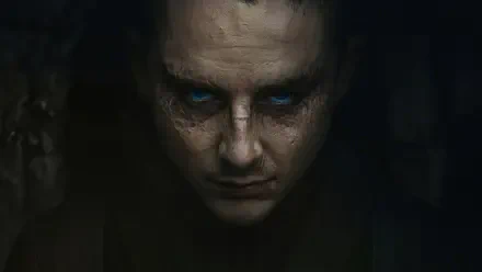 Dune: Part Three 4K Ultra HD PC desktop wallpaper — a shadowed, sand-scarred face with glowing blue eyes emerging from darkness, tense moody sci-fi portrait.