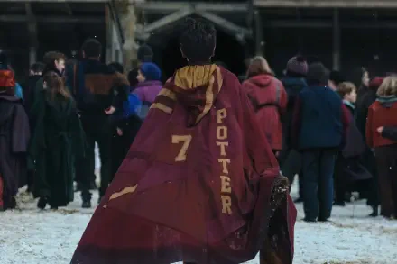 HD PC desktop wallpaper from TV show Harry Potter (2027): lone figure in maroon robe marked 7 POTTER walks across a snowy Quidditch pitch with spectators in the background.