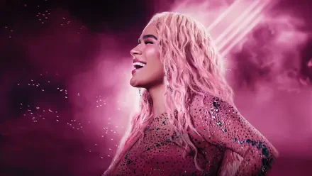 HD desktop wallpaper of a smiling female celebrity reggaeton singer in a sparkling pink outfit with long pink hair, neon pink lights and a smoky background.