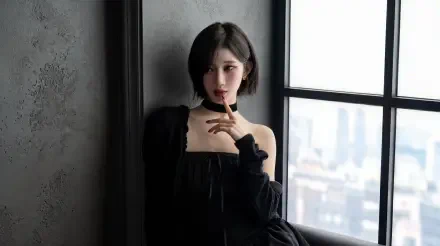 Short-haired woman in a black off-shoulder dress by a window, K-pop–inspired model styling in moody soft light — 5K Ultra HD desktop wallpaper.