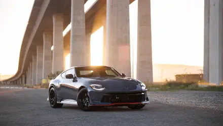 4K Ultra HD PC desktop wallpaper of a gray Nissan Z Nismo parked beneath an overpass at sunset, low-angle view with warm backlighting.