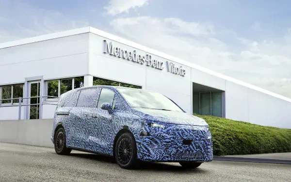 4K Ultra HD PC desktop wallpaper: camouflaged Mercedes-Benz Vitoria prototype car parked outside the Mercedes-Benz Vitoria plant under a blue sky.