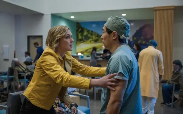 TV show Pluribus scene: a woman in a yellow jacket holds a surgeon in scrubs in a crowded hospital waiting room — 8K Ultra HD PC desktop wallpaper/background.