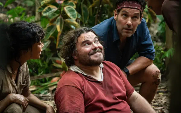 Three actors from Anaconda (2025) in a jungle scene—one seated smiling while two crouch nearby; 2K Quad HD PC desktop wallpaper background.