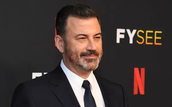 HD PC desktop wallpaper of a smiling celebrity talk-show host in a dark suit on a red-carpet backdrop with FYSEE and Netflix logos.