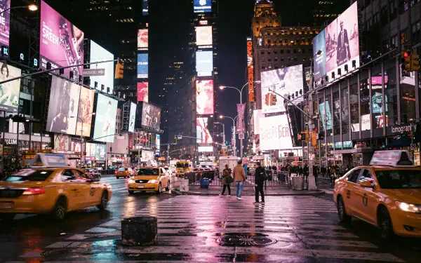 Times Square at night — 4K Ultra HD PC desktop wallpaper and background showing wet streets reflecting neon billboards, bustling pedestrians and yellow taxis in motion