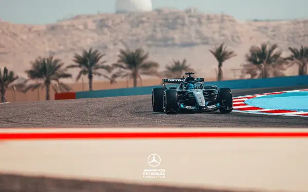 Mercedes AMG F1 race car on a desert circuit with palm trees and sand dunes — 2K Quad HD PC desktop wallpaper, F1 sports racing background.