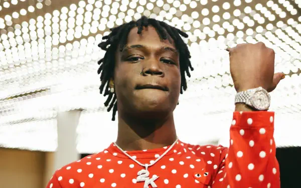 HD PC desktop wallpaper: rapper in a red polka-dot shirt, chain and watch, fist raised beneath bright studio lights.