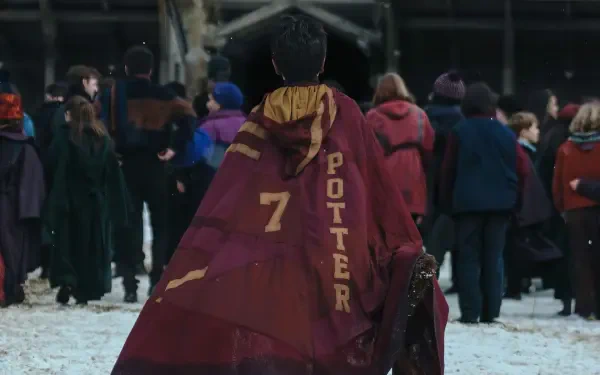 HD PC desktop wallpaper from TV show Harry Potter (2027): lone figure in maroon robe marked 7 POTTER walks across a snowy Quidditch pitch with spectators in the background.