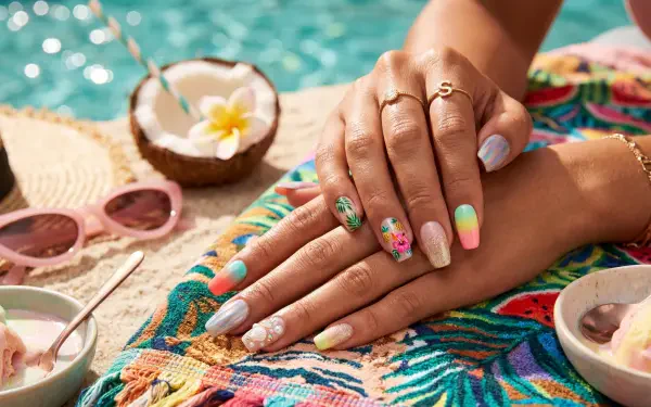 Hands with vibrant summer nail art on a tropical towel by a pool, coconut halves and sunglasses nearby — Summer Nails, 5K Ultra HD PC desktop wallpaper/background.