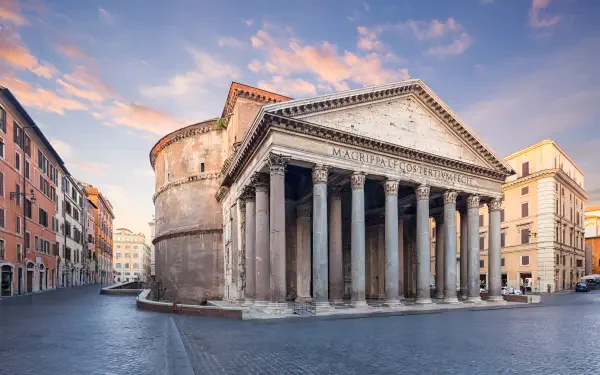 2K Quad HD PC desktop wallpaper and background of the Pantheon in Rome, Italy — classical Corinthian portico and rotunda bathed in warm sunset light, surrounded by city buildings.