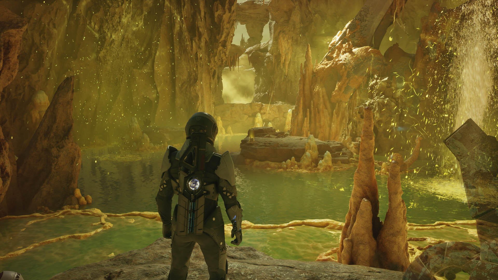 HD PC desktop wallpaper from Exodus (2027 video game): armored explorer stands in a glowing cavern above green pools, crystalline stalactites and alien rock formations.
