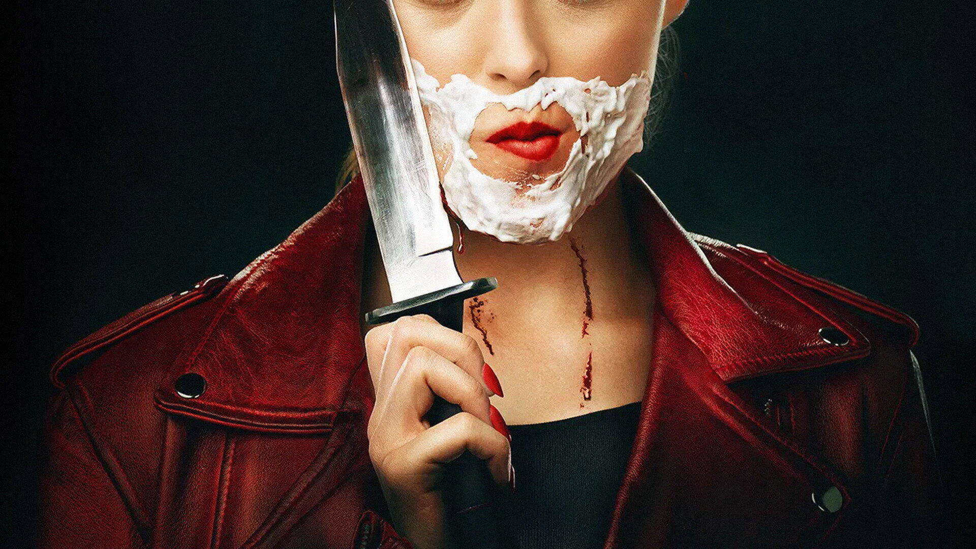 Freaky (Movie) HD PC desktop wallpaper: woman in a red leather jacket with a shaving-cream beard and red lips holds a large knife to her face, a thin trail of blood at her neck.