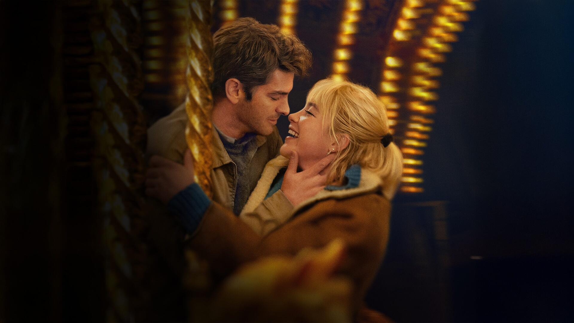 We Live in Time — 4K Ultra HD PC desktop wallpaper/background: couple embracing and kissing beneath warm, blurred carousel lights, evoking a romantic, nostalgic atmosphere.