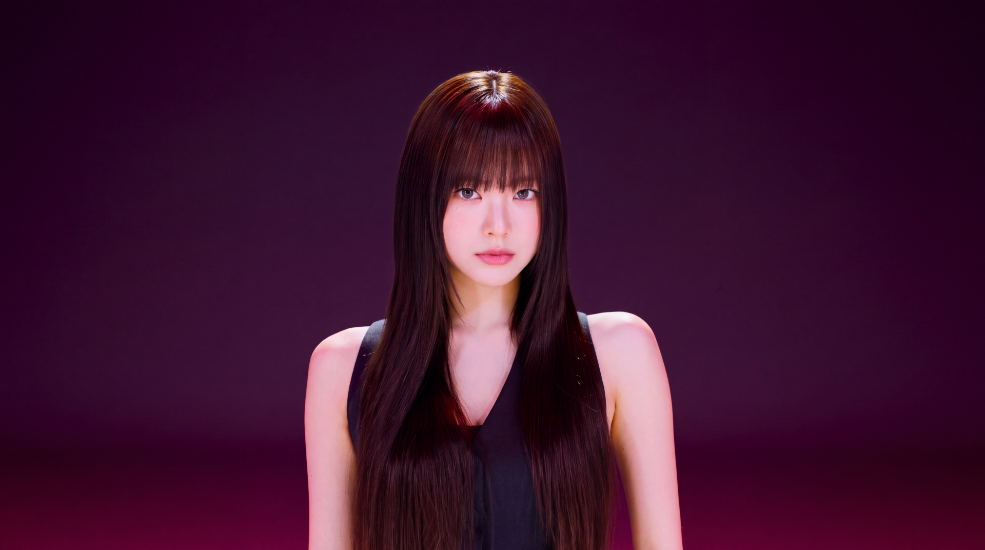 5K desktop wallpaper: studio portrait of a young woman with long dark hair and blunt bangs in a black top, centered against a deep magenta background.