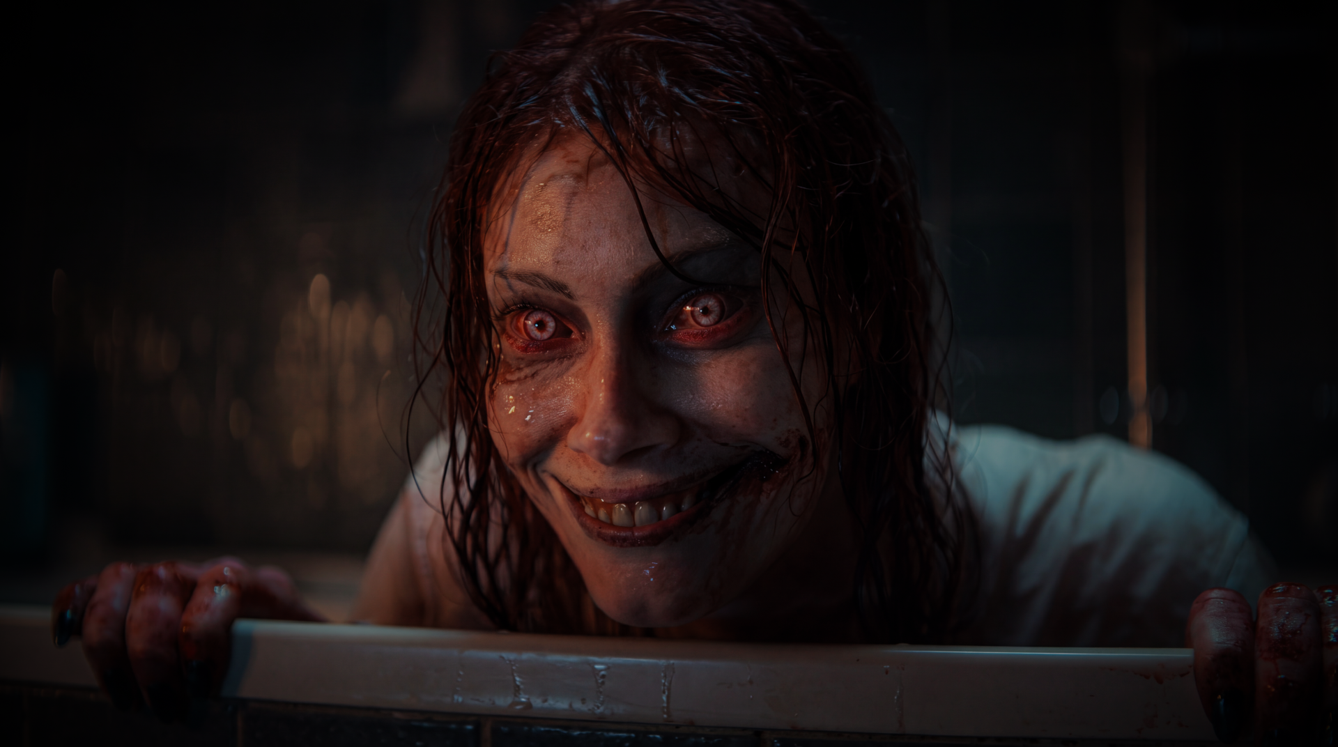 Evil Dead Rise close-up: a possessed deadite woman with bloodshot eyes, torn lips and a manic grin — horror 5K Ultra HD PC desktop wallpaper/background.
