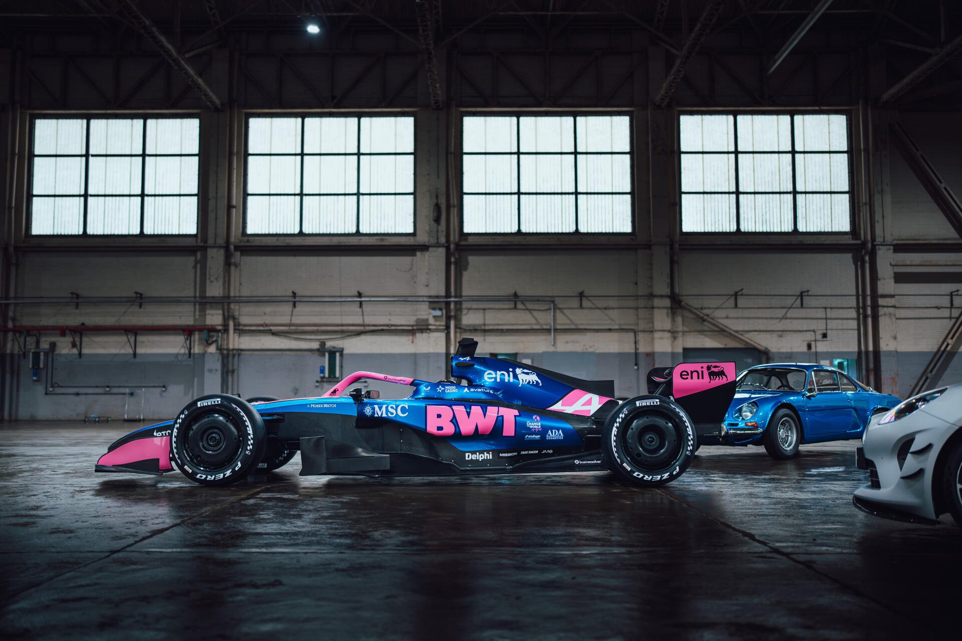 Alpine A526 F1 race car in a dark industrial garage, 8K Ultra HD PC desktop wallpaper and background.