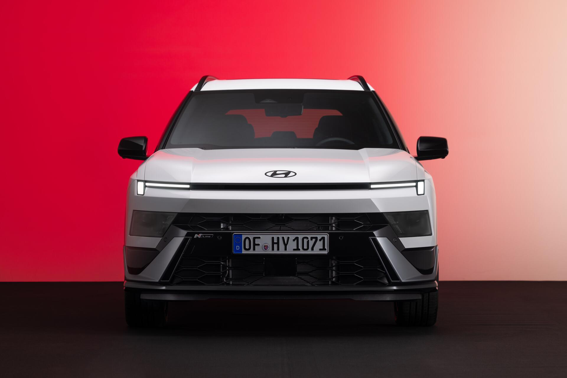 Front view of a Hyundai Bayon electric SUV against a red backdrop, featured in an 8K Ultra HD desktop wallpaper.