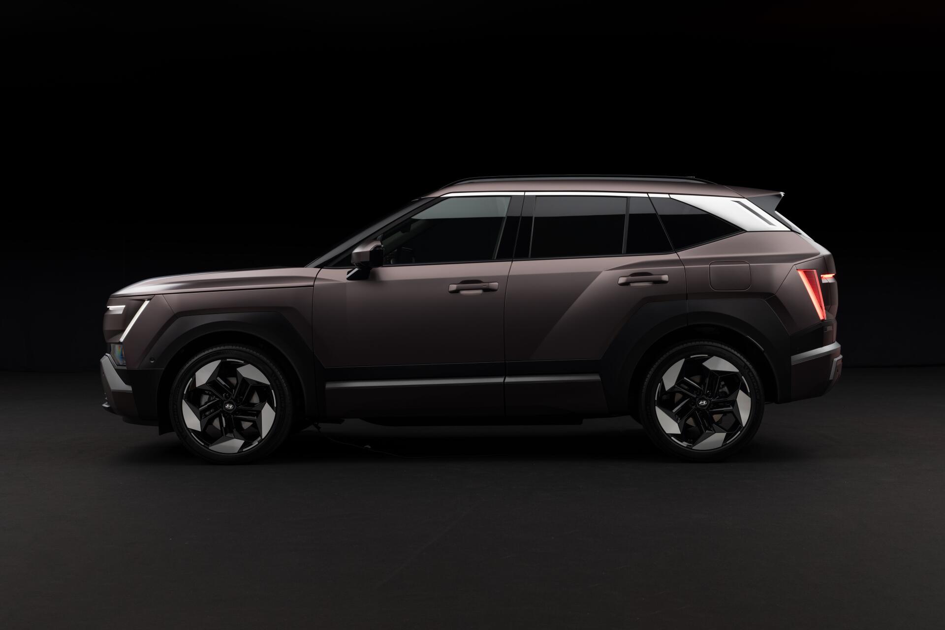 Hyundai Tucson SUV in a dark studio, shown in side profile in an 8K Ultra HD PC desktop wallpaper.