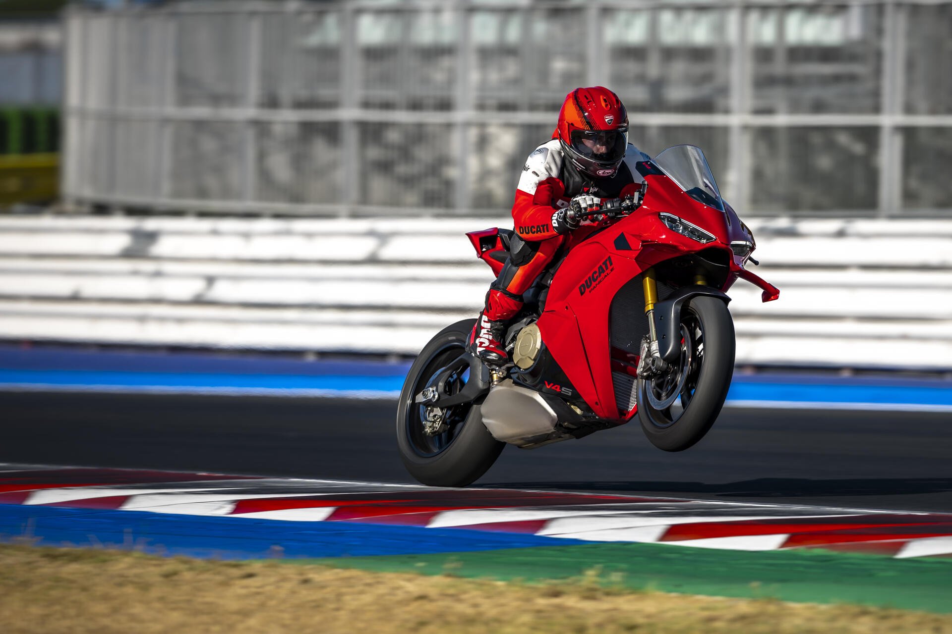 Ducati Panigale V4 and motorcycle racer speeding around a racetrack in 5K Ultra HD desktop wallpaper.
