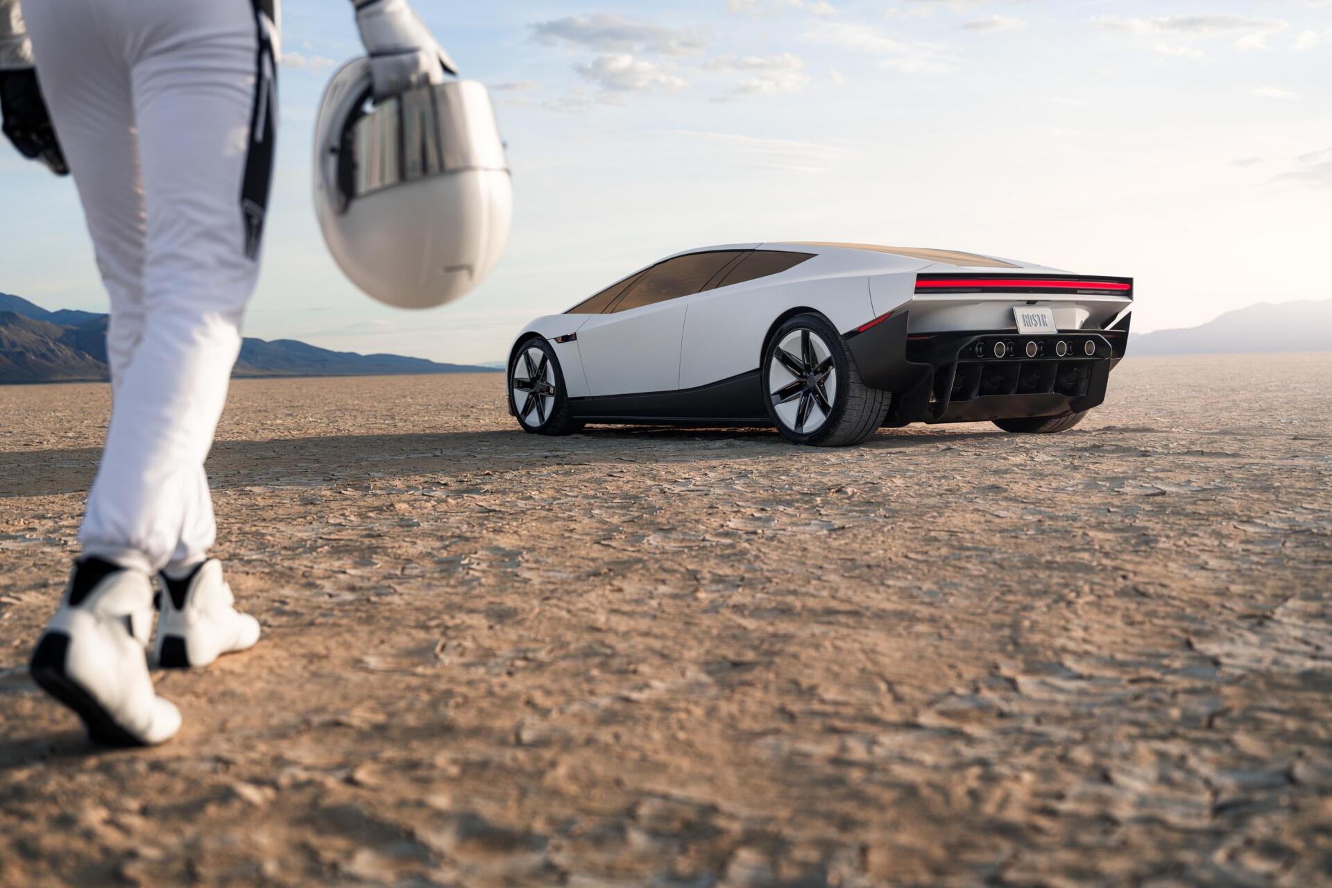 Tesla electric concept car on a desert road with a helmeted figure, featured in a 2K Quad HD PC desktop wallpaper.
