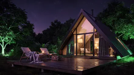 Nighttime A-frame cabin with warm interior lights, deck chairs and fire pit on a wooden platform by the trees—weekend getaway 4K Ultra HD PC desktop wallpaper and background.