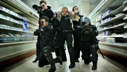 Hot Fuzz 2K Quad HD PC desktop wallpaper: six uniformed officers in tactical gear aim weapons and pose in a supermarket aisle, dramatic low-angle shot.