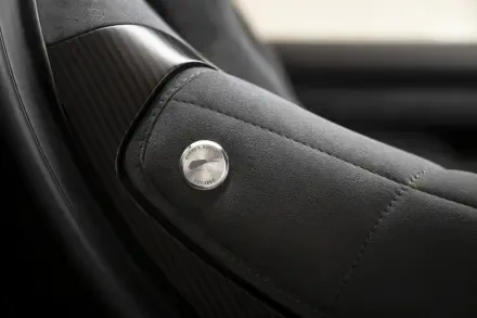 Close-up of McLaren McL 6GT leather car seat armrest with stitched detail, 8K Ultra HD PC desktop wallpaper background.