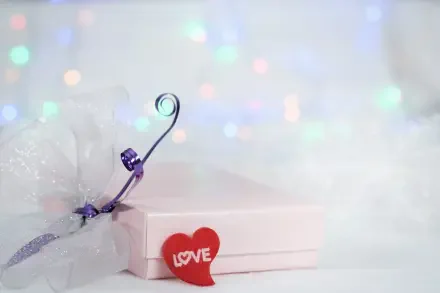4K Ultra HD PC wallpaper: aesthetic gift scene — pastel present with purple ribbon and red heart reading LOVE set against a soft electric yellow bokeh background.