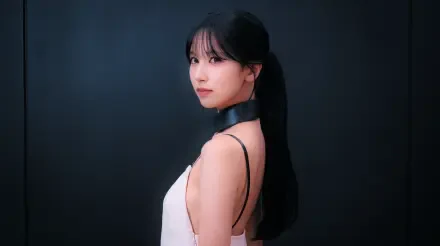 Close-up portrait of a woman with a long black ponytail in a white sleeveless top and black choker, posed against a dark backdrop — 5K PC desktop wallpaper.