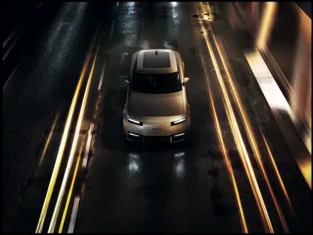 Jaguar Type 01 driving along a rain-slick road at night, 8K Ultra HD PC desktop wallpaper and background.