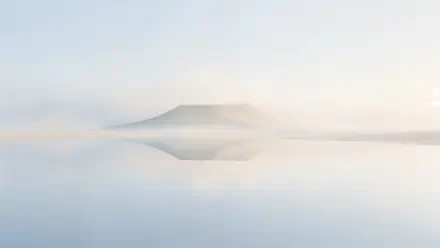Clean 4K Ultra HD PC desktop wallpaper of a misty mountain reflected in a calm lake, with soft fog and a serene minimalist landscape.