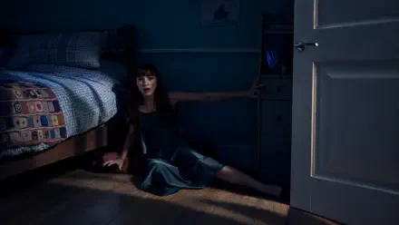 4K Ultra HD Other Mommy wallpaper: a woman sits on the bedroom floor beside a bed, reaching toward an open door in a dark room.
