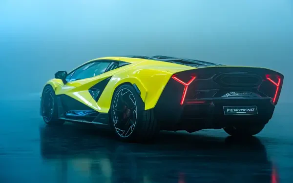 Yellow Lamborghini Fenomeno on a reflective wet floor with blue haze, rear three-quarter view — 2K Quad HD PC desktop wallpaper/background.