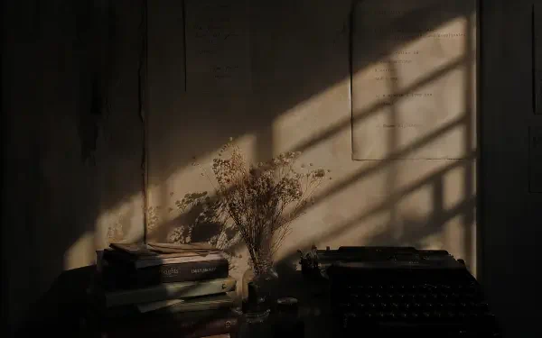 Poetcore 4K Ultra HD PC desktop wallpaper and background: moody study corner with stacked books, vintage typewriter and dried bouquet lit by window shadows.