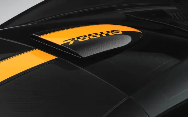 Close-up of a black carbon-fiber McLaren 788HS rear deck with yellow stripe and 788HS badge — 8K Ultra HD PC desktop wallpaper and background, vehicle detail.