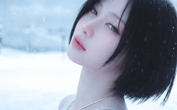 K-pop–styled Japanese model with short black hair gazes over her shoulder as snow falls around her, soft pale tones in a 5K Ultra HD desktop wallpaper.