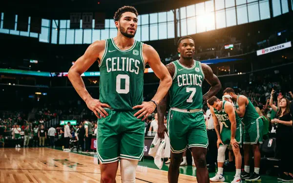 4K Ultra HD desktop wallpaper of Boston Celtics basketball players on court — two athletes in green uniforms (numbers 0 and 7) during a game, arena lights and crowd behind them.