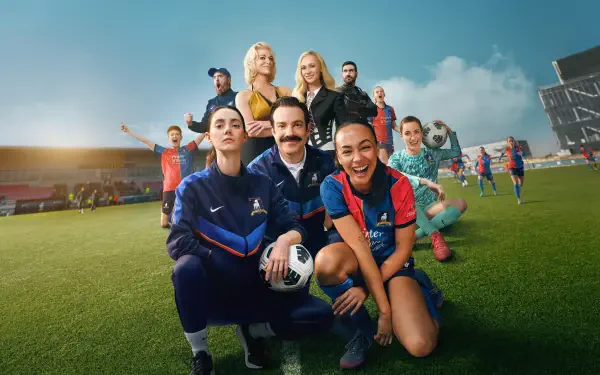 Ted Lasso cast posing on a sunlit soccer pitch, smiling and holding a ball — vibrant 4K Ultra HD PC desktop wallpaper and background.