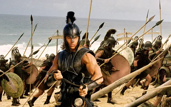 Scene from Troy: Trojan warriors in bronze armor charging across a sandy beach, spears raised — 4K Ultra HD PC desktop wallpaper and background.