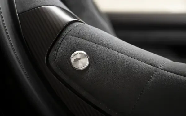 Close-up of McLaren McL 6GT leather car seat armrest with stitched detail, 8K Ultra HD PC desktop wallpaper background.
