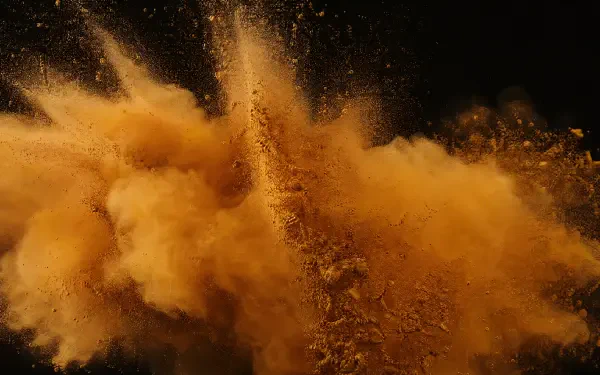 Ochre powder explosion cloud billowing against a black backdrop — dramatic 4K Ultra HD PC desktop wallpaper/background.