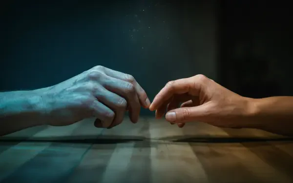 Moody 4K Ultra HD desktop wallpaper: close-up of two hands and fingers reaching for human touch, a quiet tactile connection bathed in blue-green light.